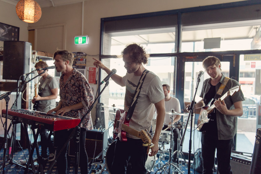 A shot of the whole band by the front glass doors of the pub.